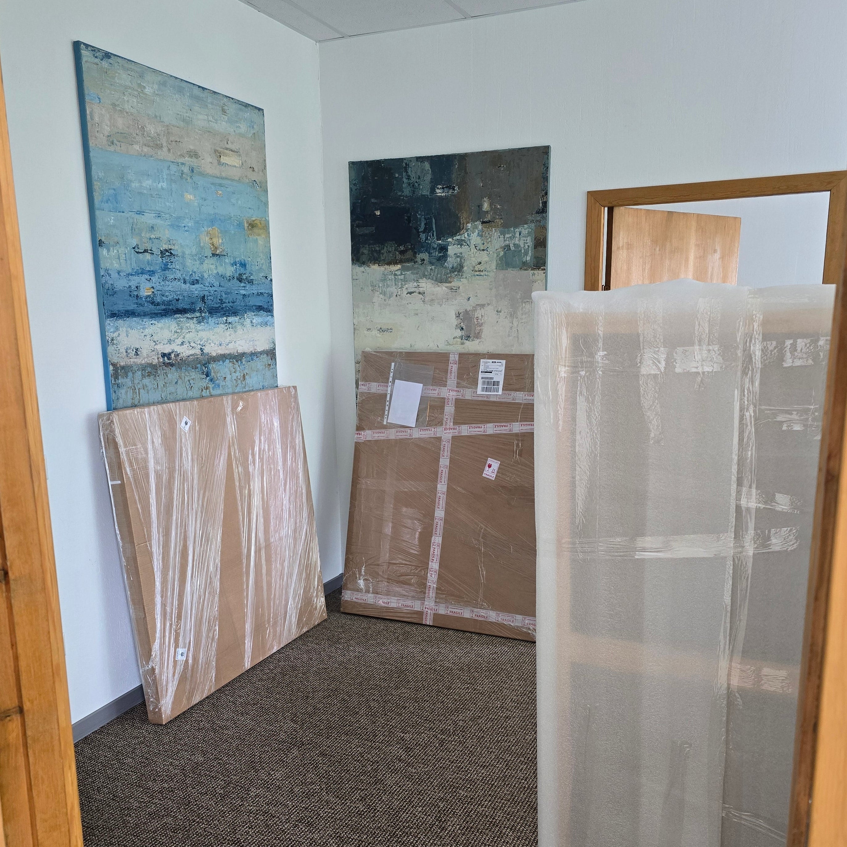An interior room view showing several large art canvases and wrapped ready to be shipped from BIRUTE STUDIO to US and Canada.
