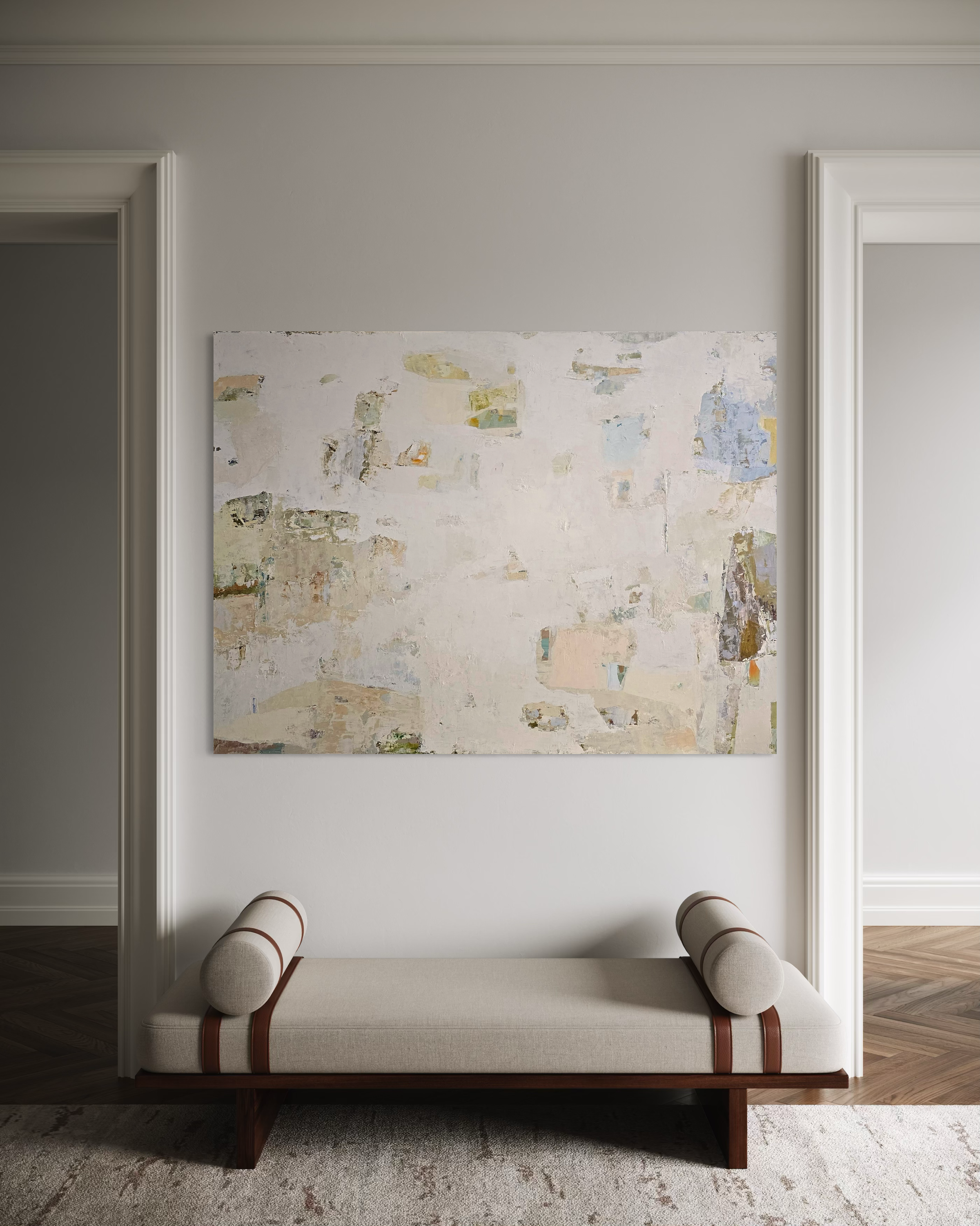 An abstract canvas painting with textured beige, cream, and soft blue tones hangs on a light gray wall above a modern beige bench with brown leather straps in a symmetrical interior setting.