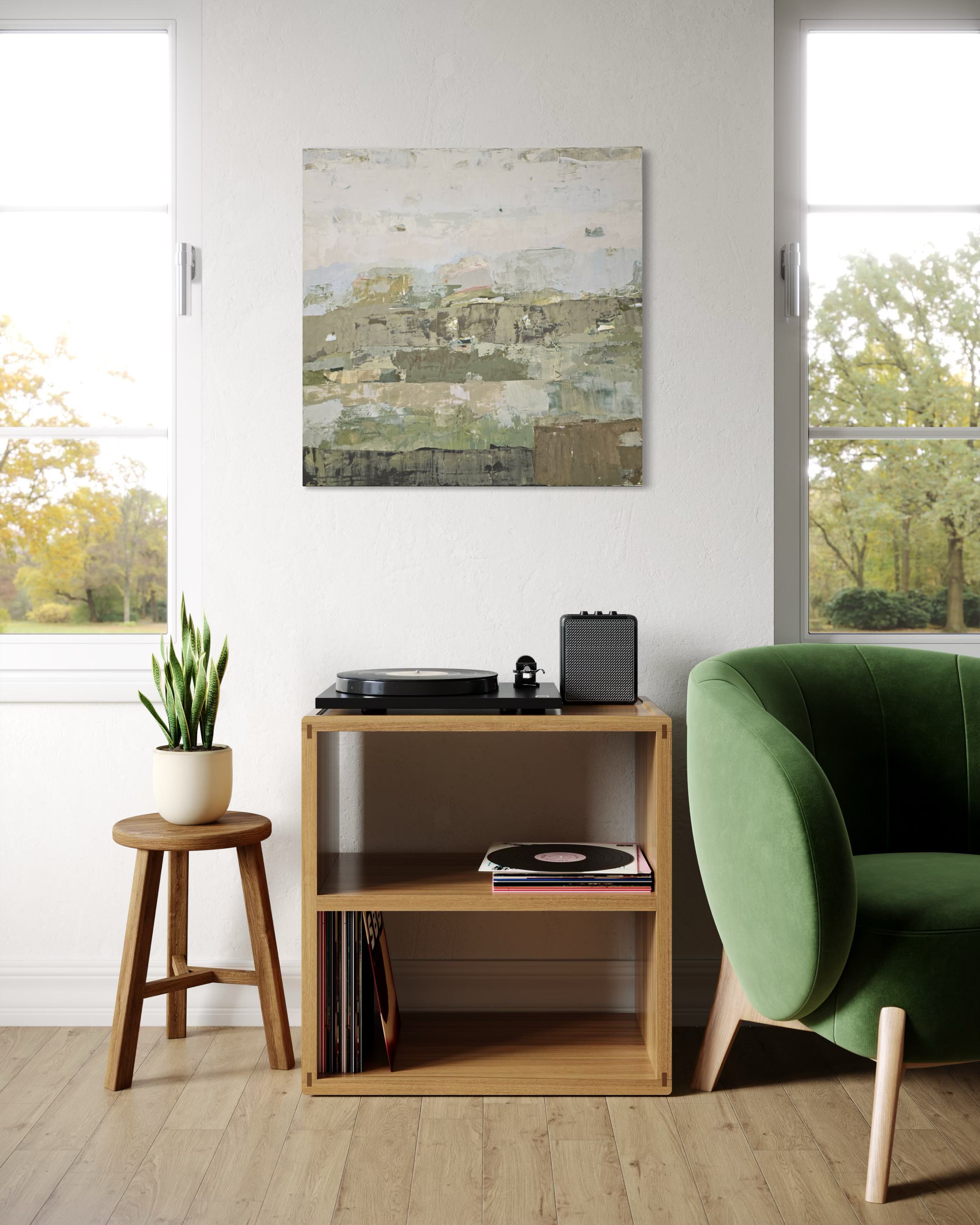 An abstract canvas painting in muted green, beige, and gray tones hangs on a white wall in a bright, modern living room. Below the painting is a light wood shelf holding a turntable, records, and a small speaker, next to a green armchair and a small wooden stool with a potted plant.