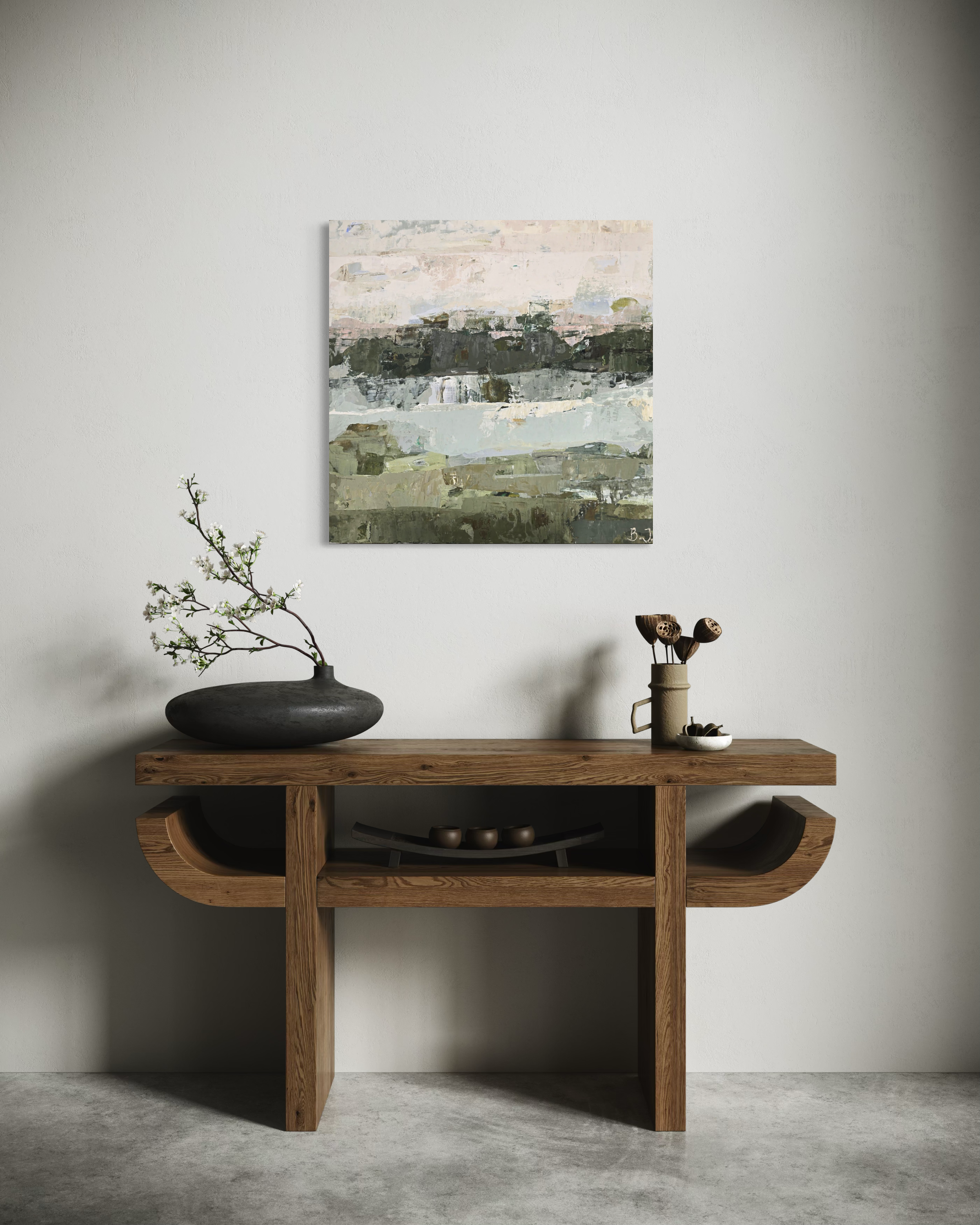 An abstract landscape painting in muted earthy tones hangs on a light gray wall above a rustic wooden console table styled with a black vase and branches.